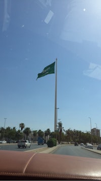 the saudi flag flying over a city