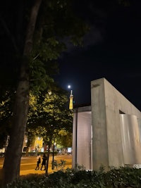 the eiffel tower at night in front of a white building